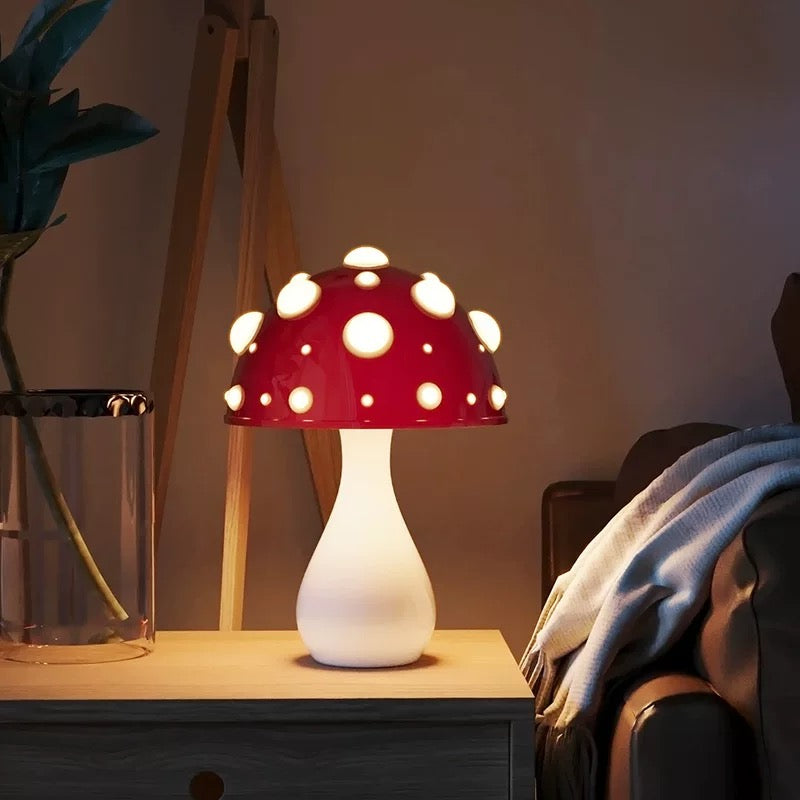 Mushroom-shaped lamp with red top and white base on a wooden surface.