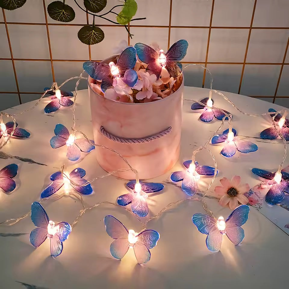 Decorative string lights with butterfly designs on a cake against a tiled wall background