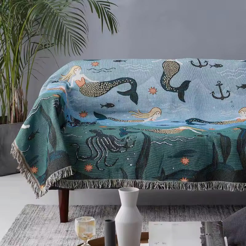 Mermaid-themed blanket draped over a sofa in a living room setting.