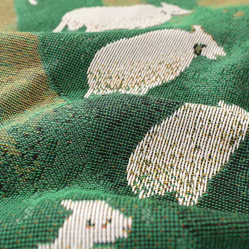 Cozy woven blanket with sheep pattern used as farmhouse bed throw.