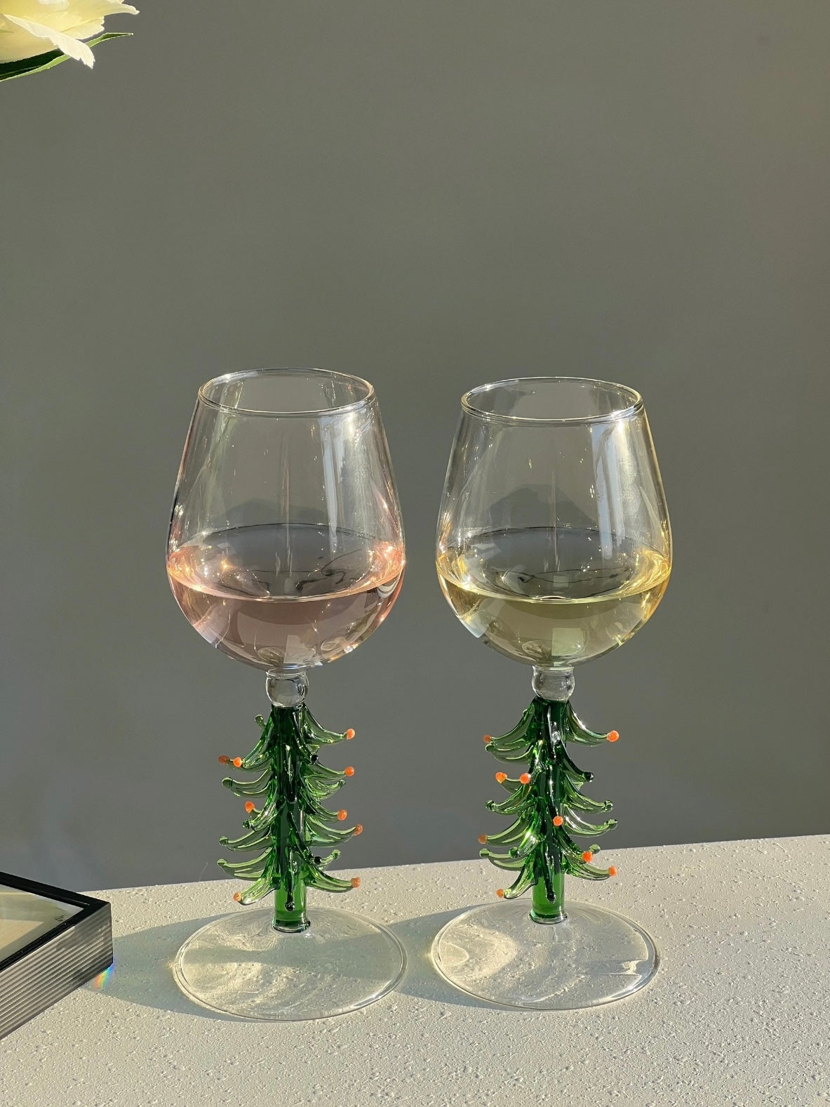 Festive wine glasses with green tree stems in a neutral table setting