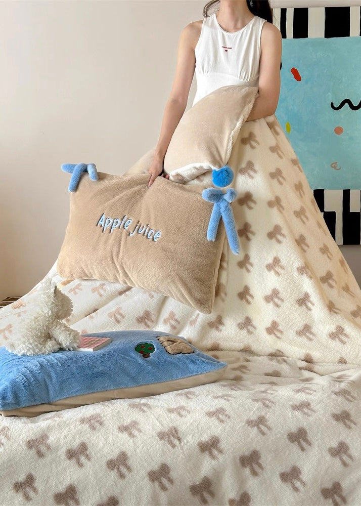 Person wrapped in a blanket with plush toys and a pillow on a bed.