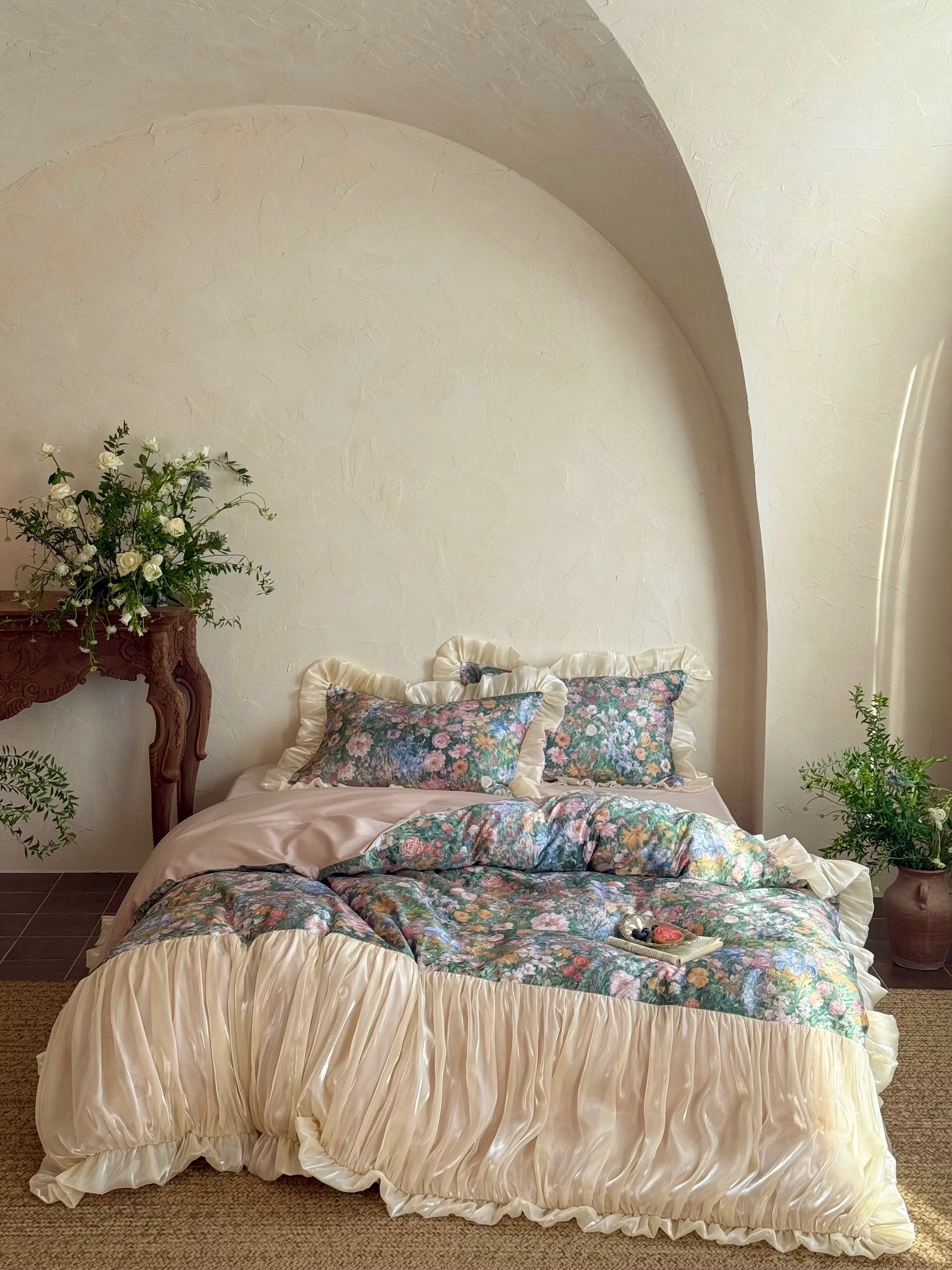 Bed with floral bedding in a room with white walls and decorative elements.