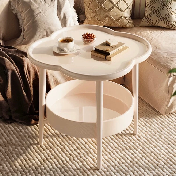 Aesthetic clover-shaped cream coffee table with book and cup on top in cozy living room