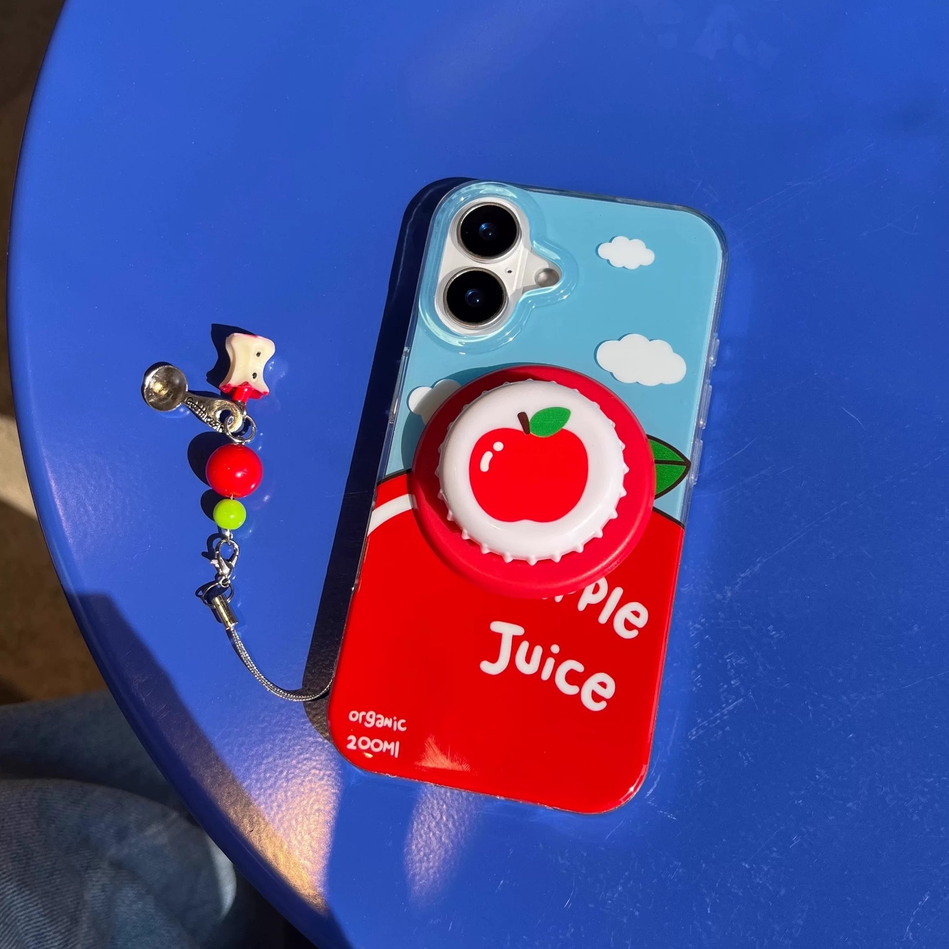 Red and blue Apple Juice MagSafe case with keychain charm. Kawaii Apple Juice iPhone cover with pop socket style griptok.