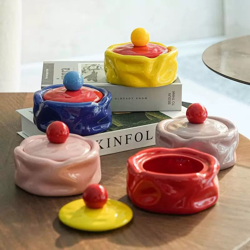 Colorful ceramic containers with lids on a wooden surface