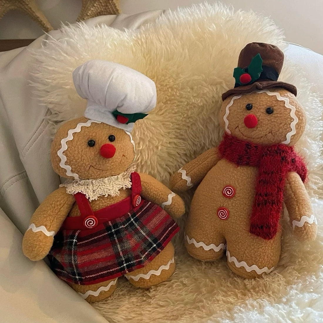 Standing gingerbread doll pair in brown with a red scarf, plaid skirt, white chef hat and brown top hat.