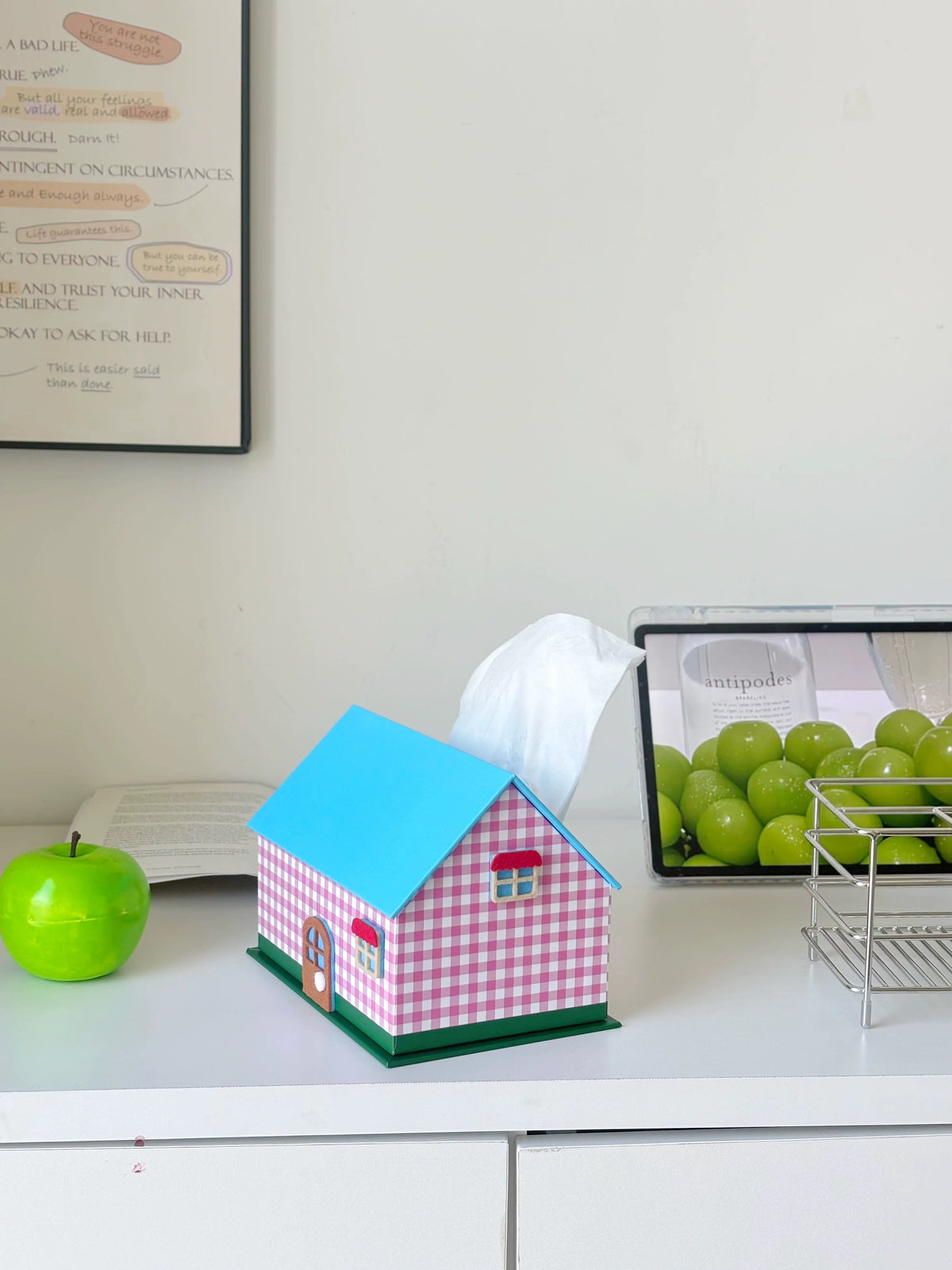 Pink gingham house tissue box cover with tissue pulled through the roof opening