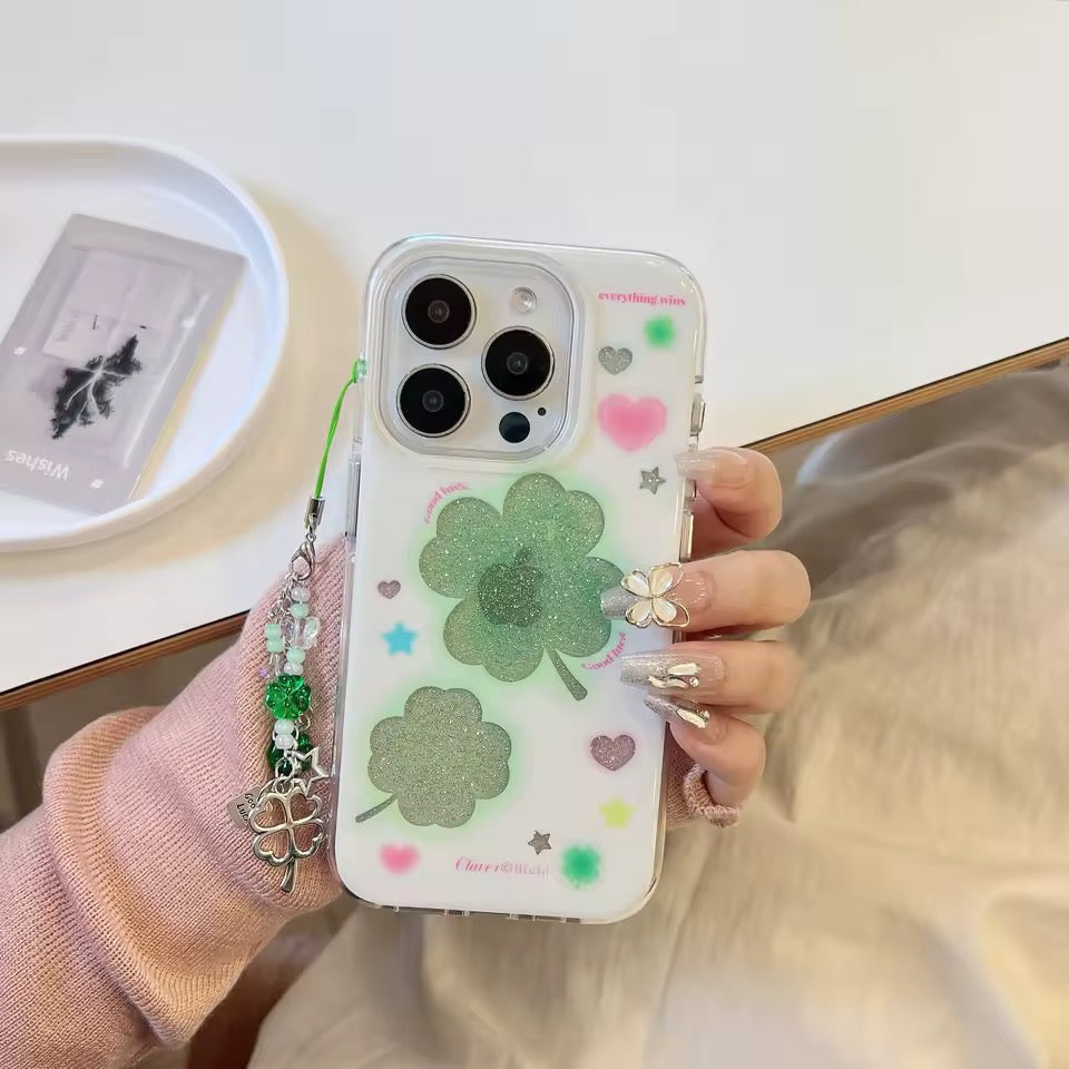 Phone case with clover design held by a person