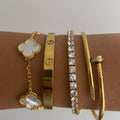 Love Bracelet in 18K gold plating on a wrist with a heart charm