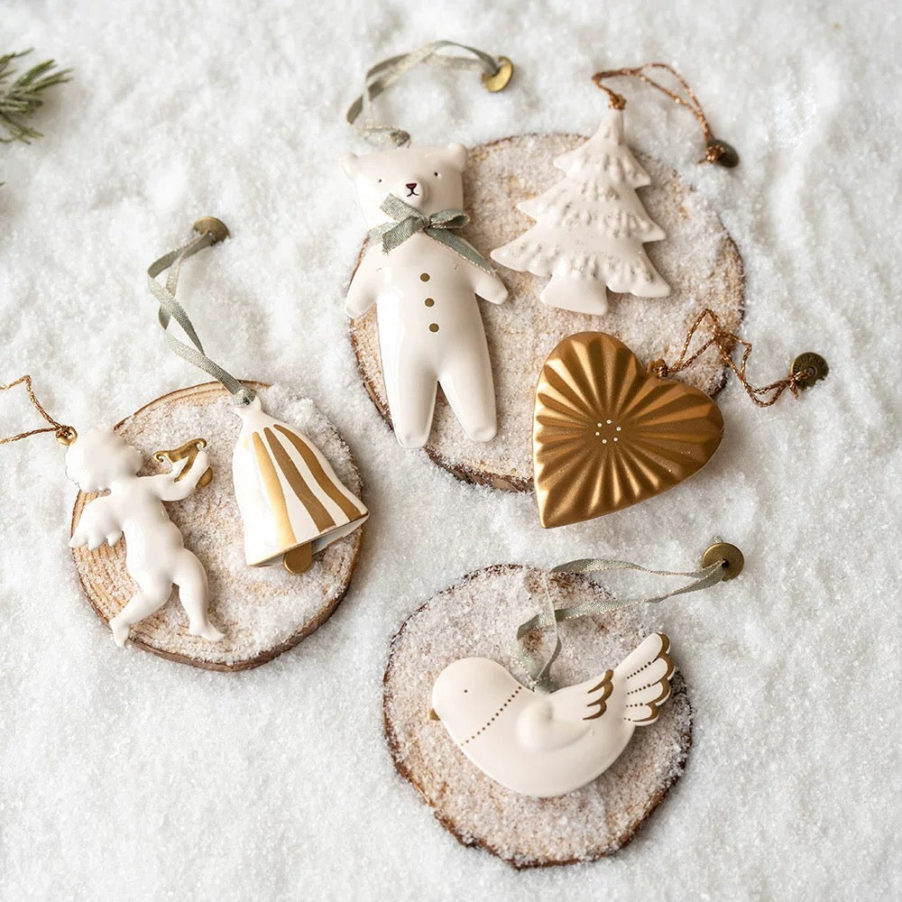 Gold and white Christmas ornaments include a heart, striped bell, white dove, polar bear and white tree.