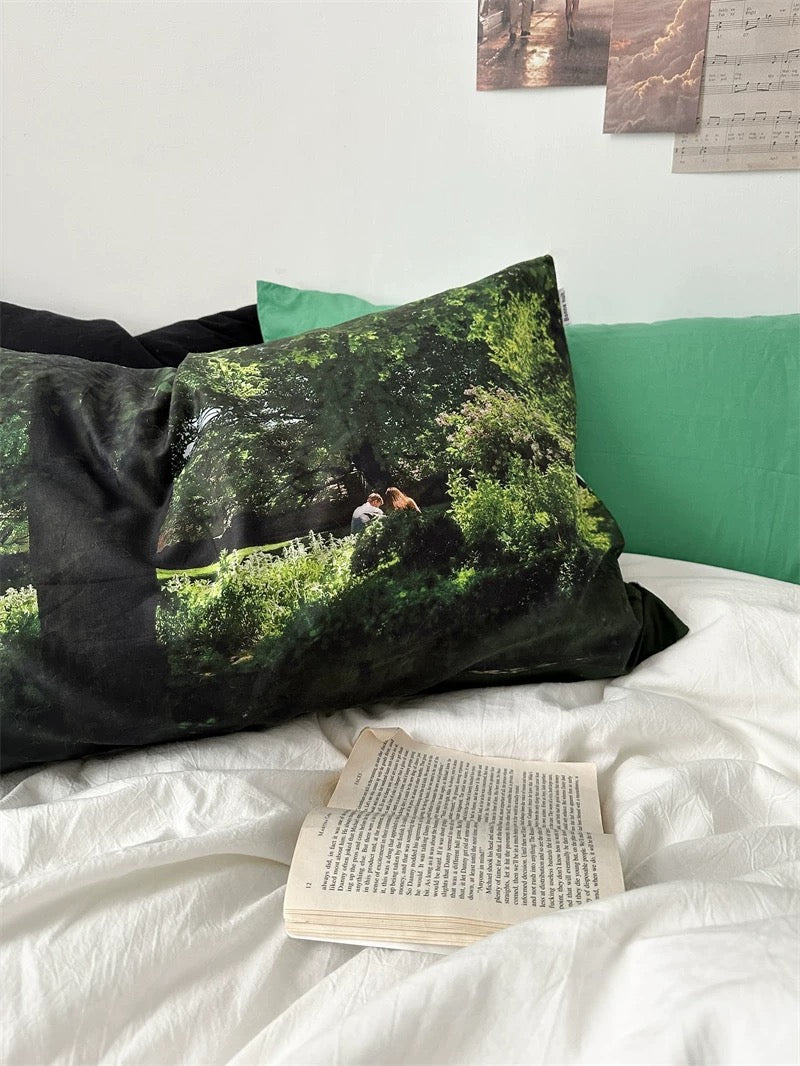 Decorative pillows with nature scene on a bed with a book