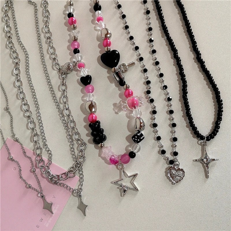 Gothic Y2K aesthetic necklace featuring pink beaded chain with butterfly and heart pendants, perfect for soft emo and 2000s-inspired looks.