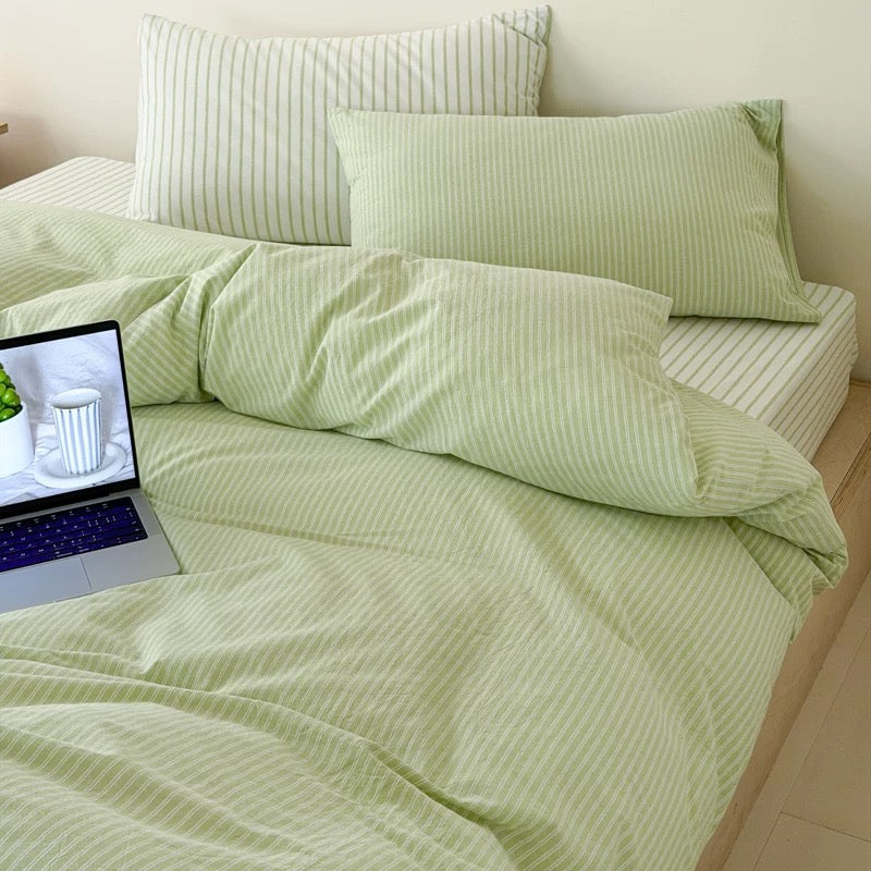Breathable cotton duvet cover featuring delicate pistachio stripes paired with matching pillowcases and flat sheet together.