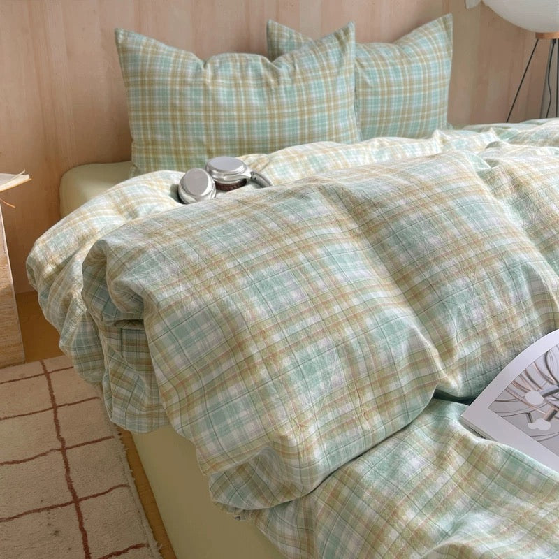 Bed with plaid bedding and pillows in a room setting