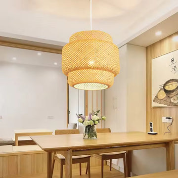Handwoven bamboo pendant light casting warm glow in modern Japandi bedroom.