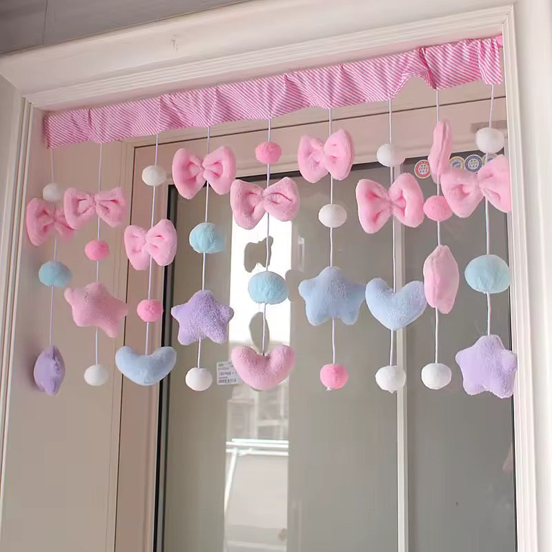 Kawaii pink bow curtain with heart and star tassels used as doorway divider.