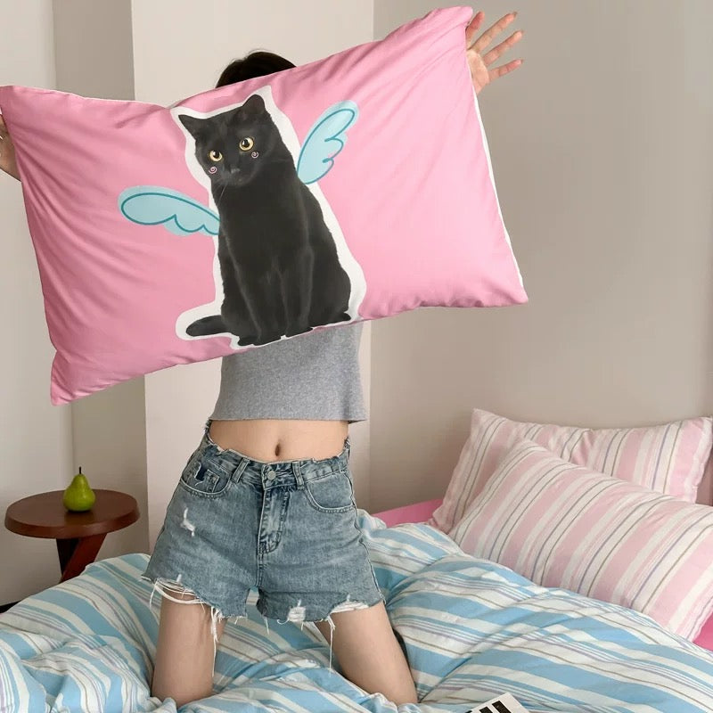 Person holding a pink pillow with a black cat design in a bedroom setting