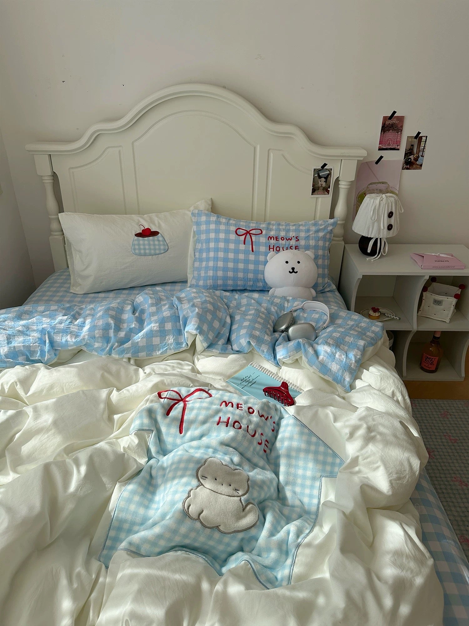Coquette-style bedding with cute cat embroidery and blue gingham pillow.