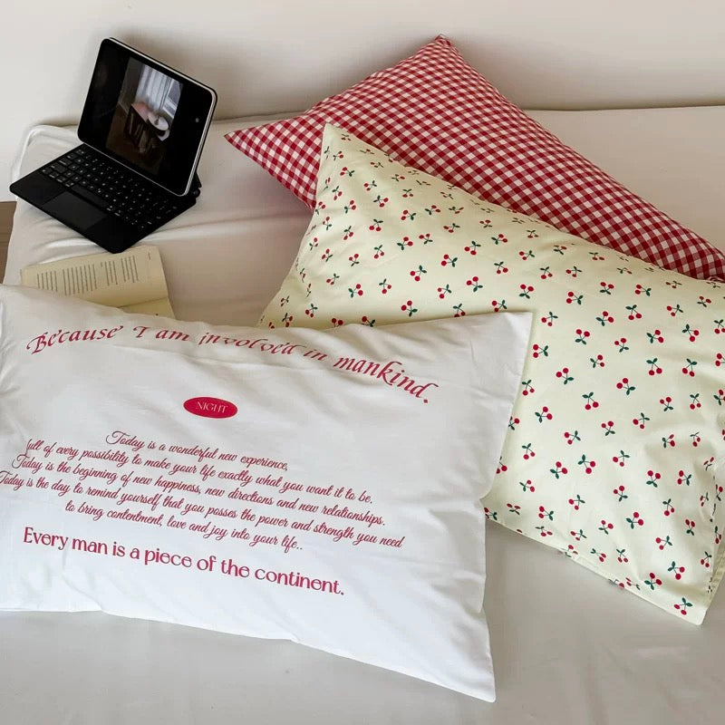 Preppy college dorm decor featuring red gingham pillow cover and plaid blanket.