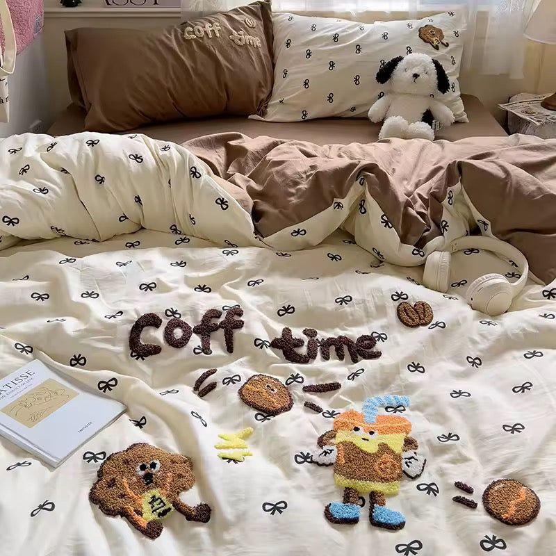 Detailed view of the embroidered pillowcases showing cute coffee beans and cups on a cream background.