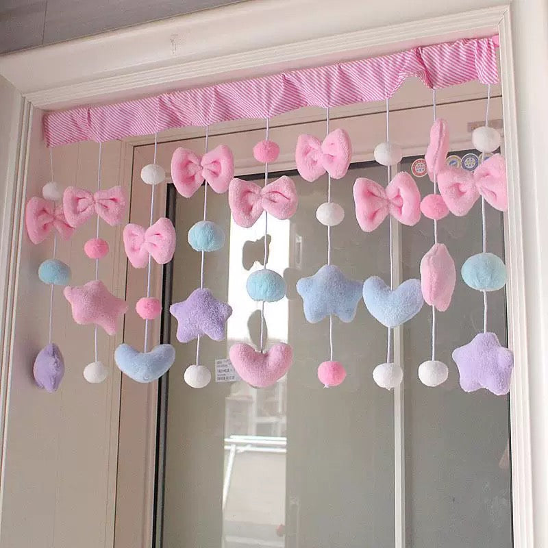 Pastel pink curtain with plush bows and hearts as window valance decor.