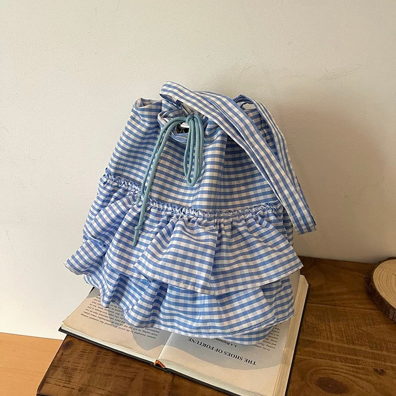 Blue and white striped dress on a wooden surface with an open book underneath