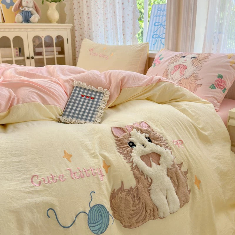 Children's bedroom with pink and yellow bedding featuring a cat design.