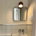 Portable makeup mirror with rectangular silvery frame. Nordic design for stylish bathroom and vanity setups.