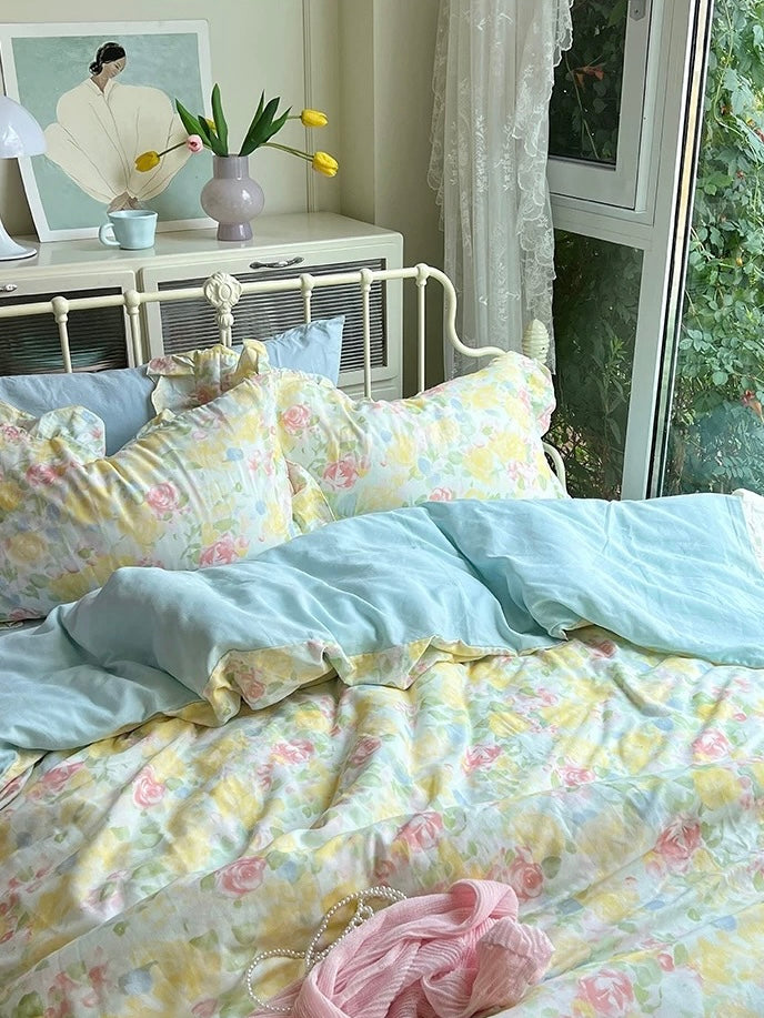 Light blue sheet folded across a printed floral cotton duvet cover