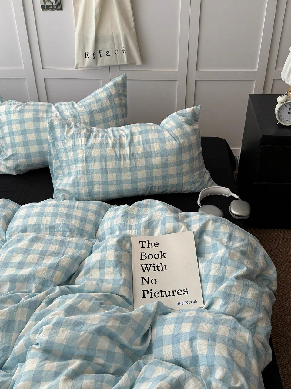 Light blue gingham duvet cover with black pillows on a styled preppy bed