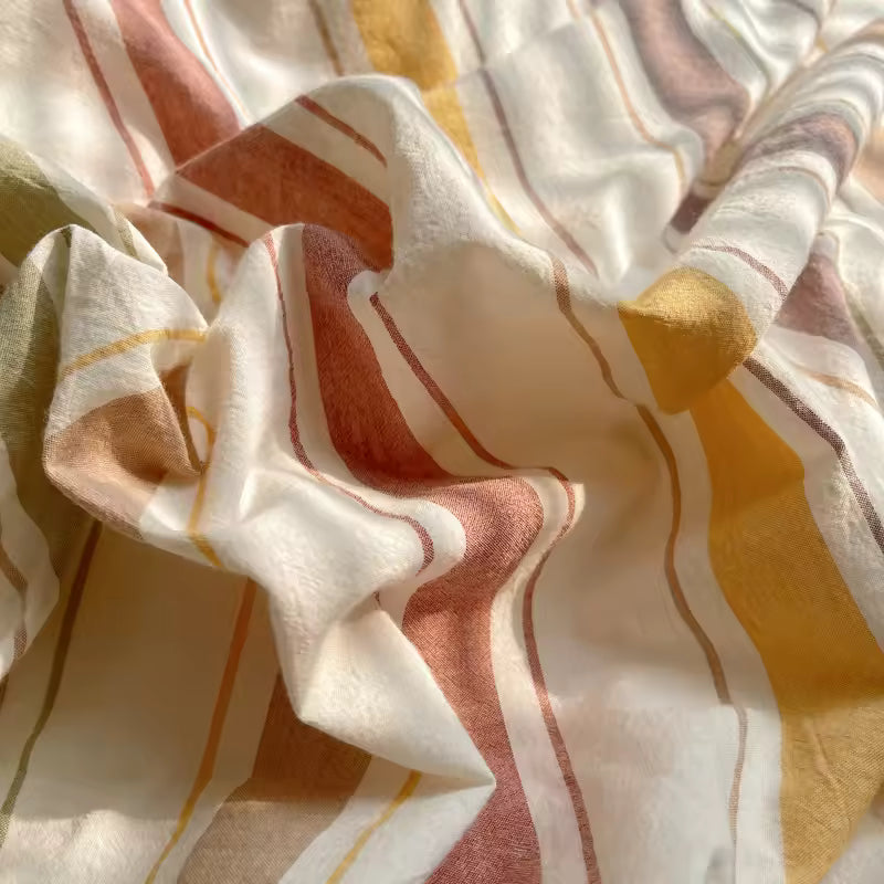 Close-up of patterned fabric with wavy lines in beige, brown, and yellow.