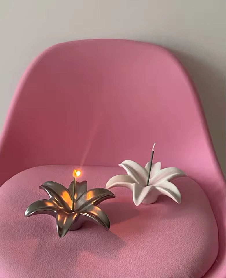 Two decorative plant-shaped candles on a pink chair.