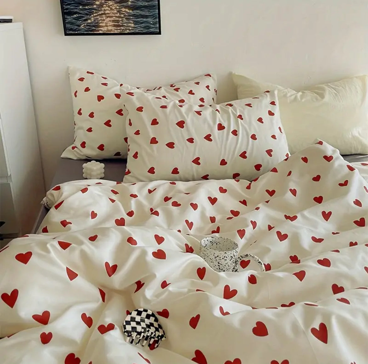 Heart print duvet cover and matching pillowcases on bed with mug and checker hair clip