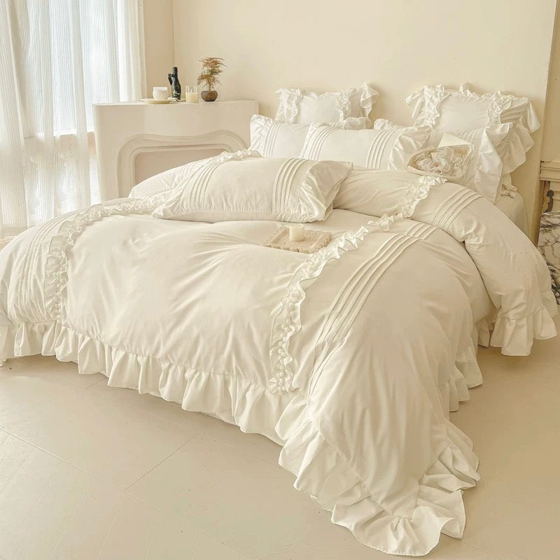 Beige ruffled bedding set on a bed in a softly lit bedroom.
