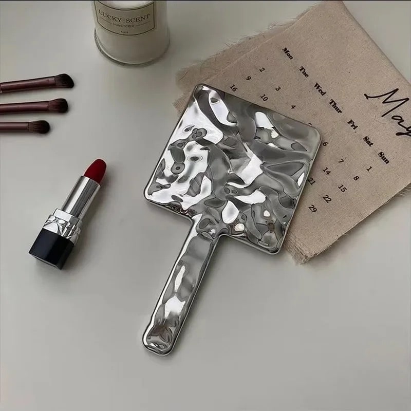 Melted metallic handheld mirror with liquid wave design