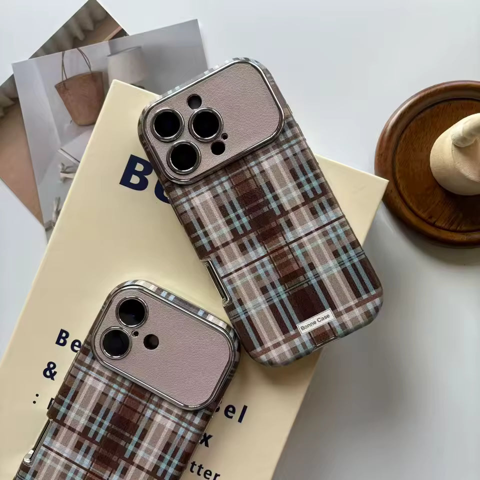 Plaid patterned phone cases on a book with a minimal background