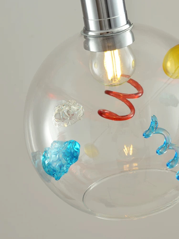 Decorative light bulb with colorful heart-shaped designs on a plain background