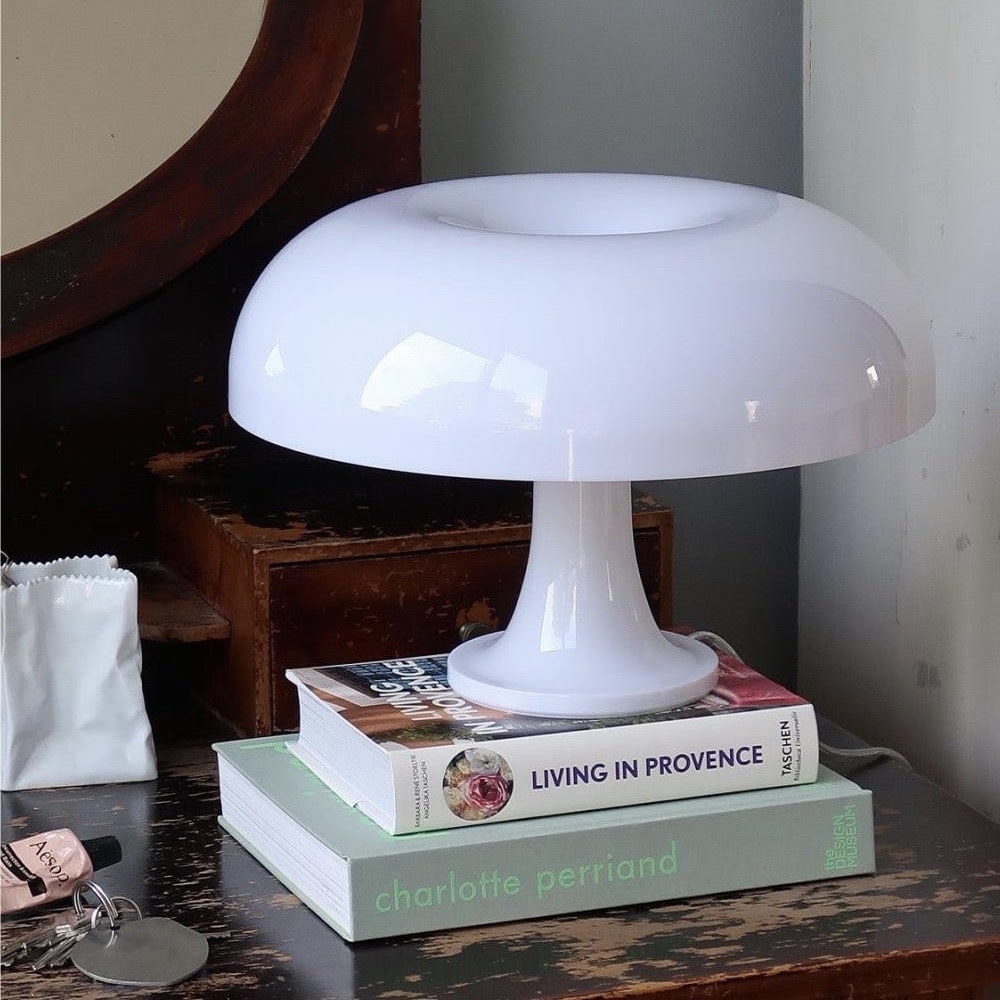 White and orange mushroom table lamp with mid-century modern design. Decorative light for minimalist and vintage interiors.