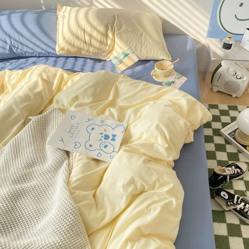 Blue fitted sheet with cream duvet cover, styled with aesthetic decor for a minimalist room.