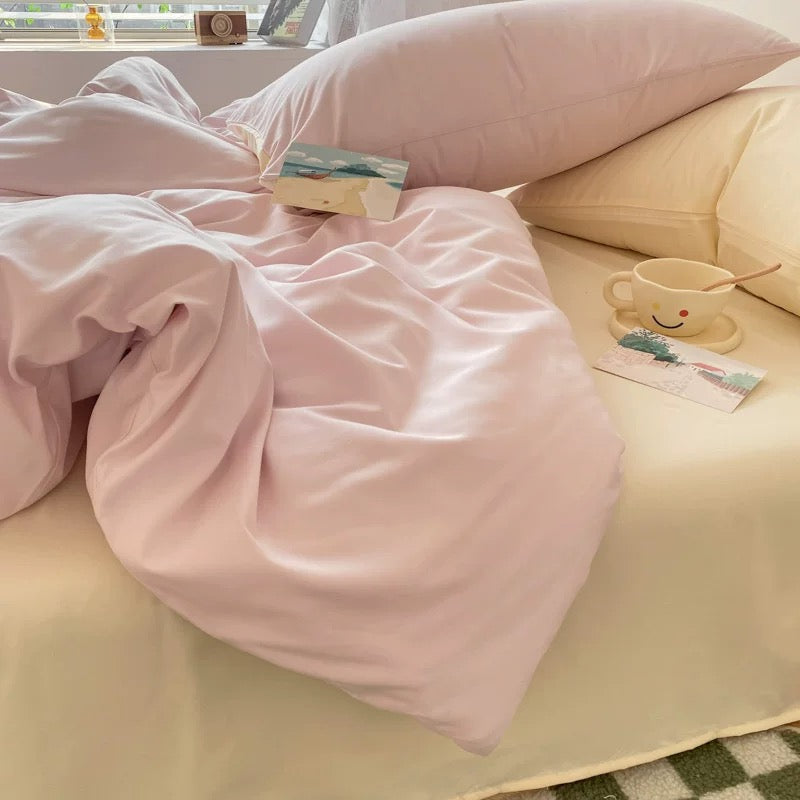 Aesthetic pastel bedding with blush pink comforter and cream pillows styled for soft girl bedroom.