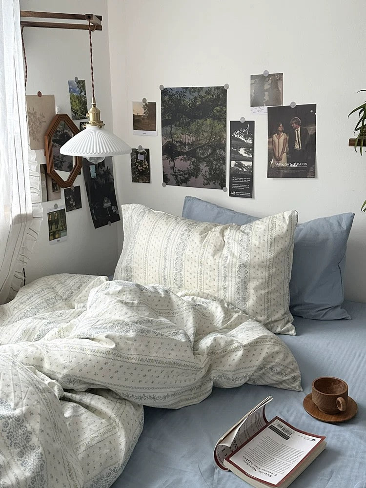 Blue stripe floral bedding complementing minimalist wooden furniture and natural lighting inside cozy personal sleep space beautifully.