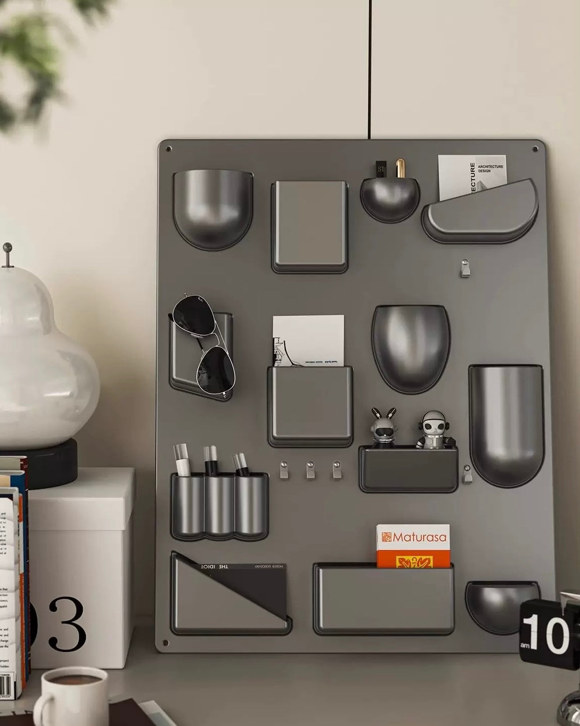 Gray wall-mounted organizer with various items on a neutral background