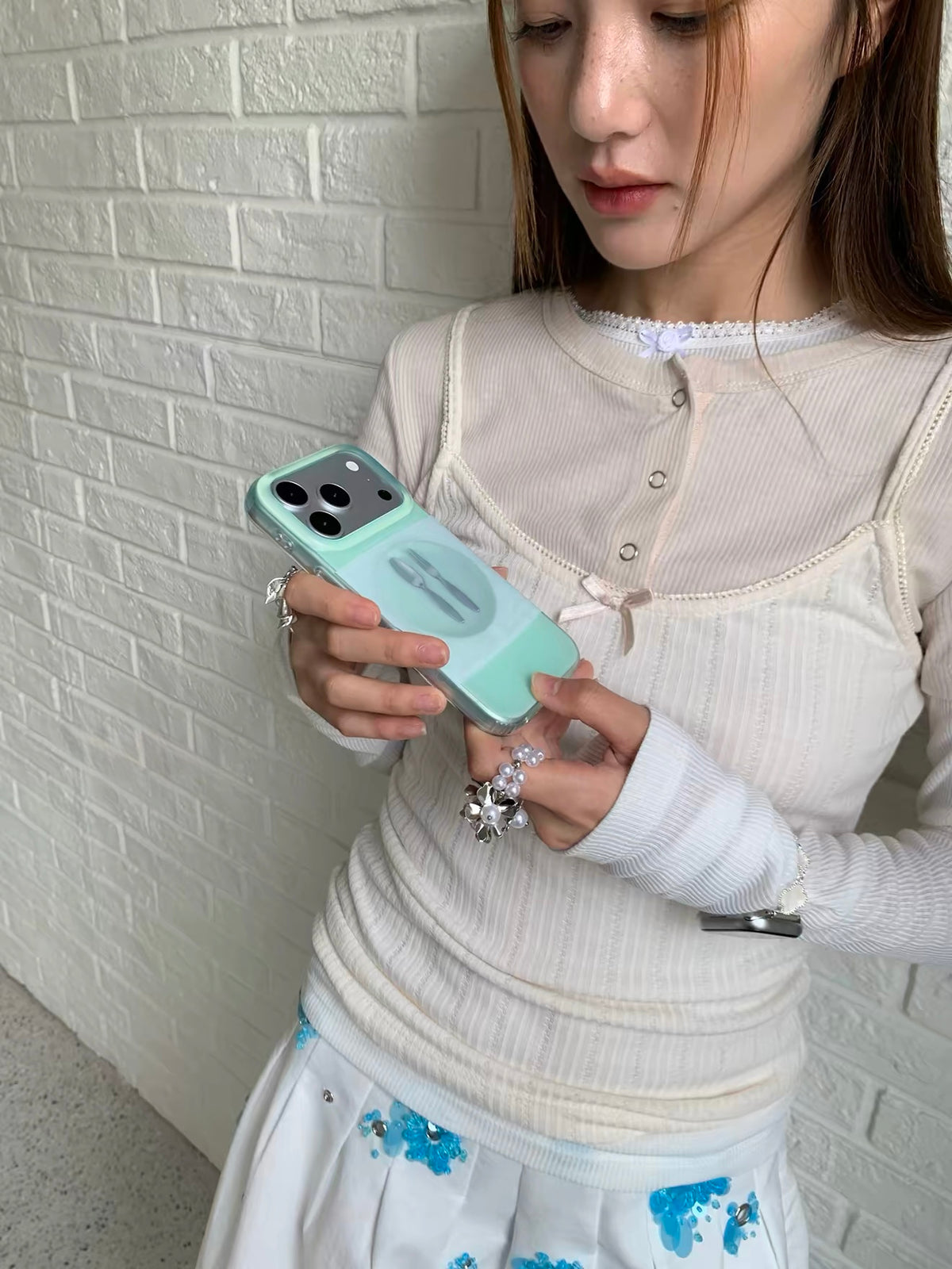 A mint spoon phone case held at an angle, showing the back design and the raised camera opening.