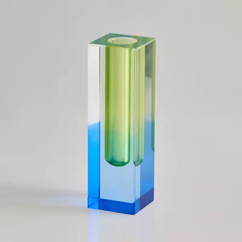 Gradient glass vase transitioning from green to blue on a light gray background