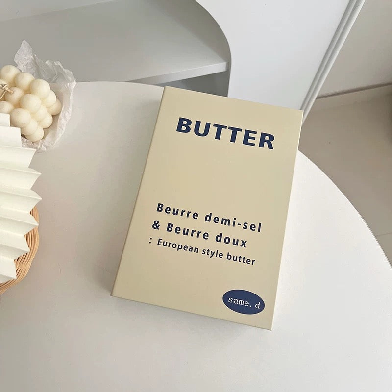 Butter packaging with 'same.' branding on a light surface