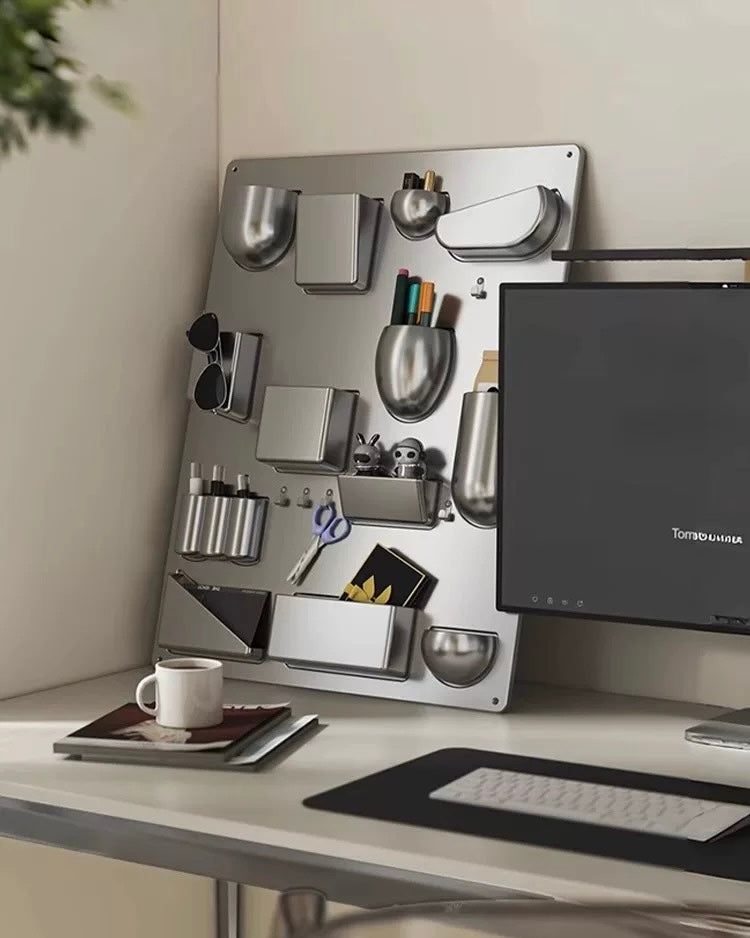 Desk setup with a computer monitor, keyboard, and various office supplies on a magnetic board.