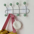 Pink wall mounted coat rack for organizing hats, bags, and towels