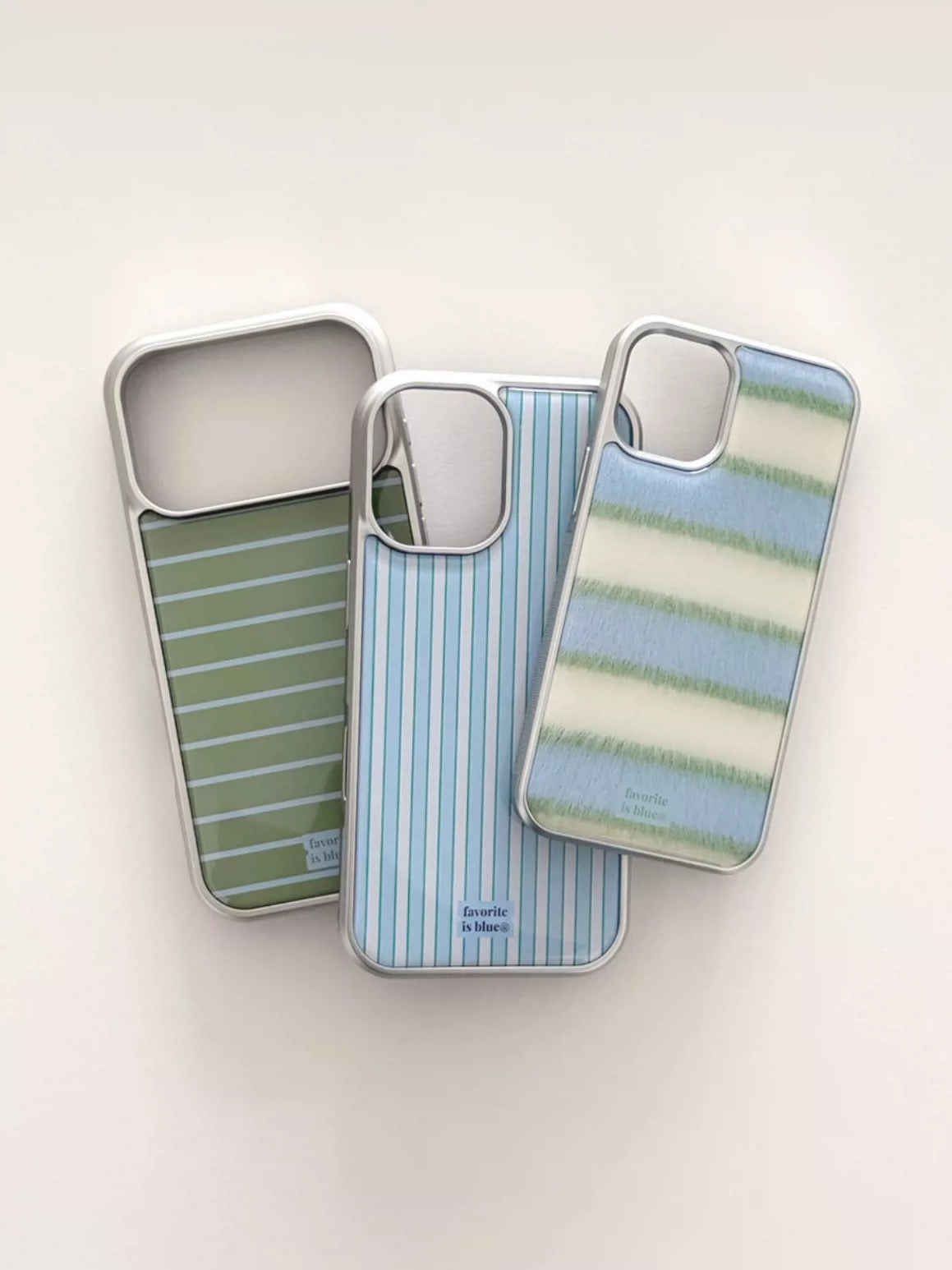 Three striped phone cases on a light beige background
