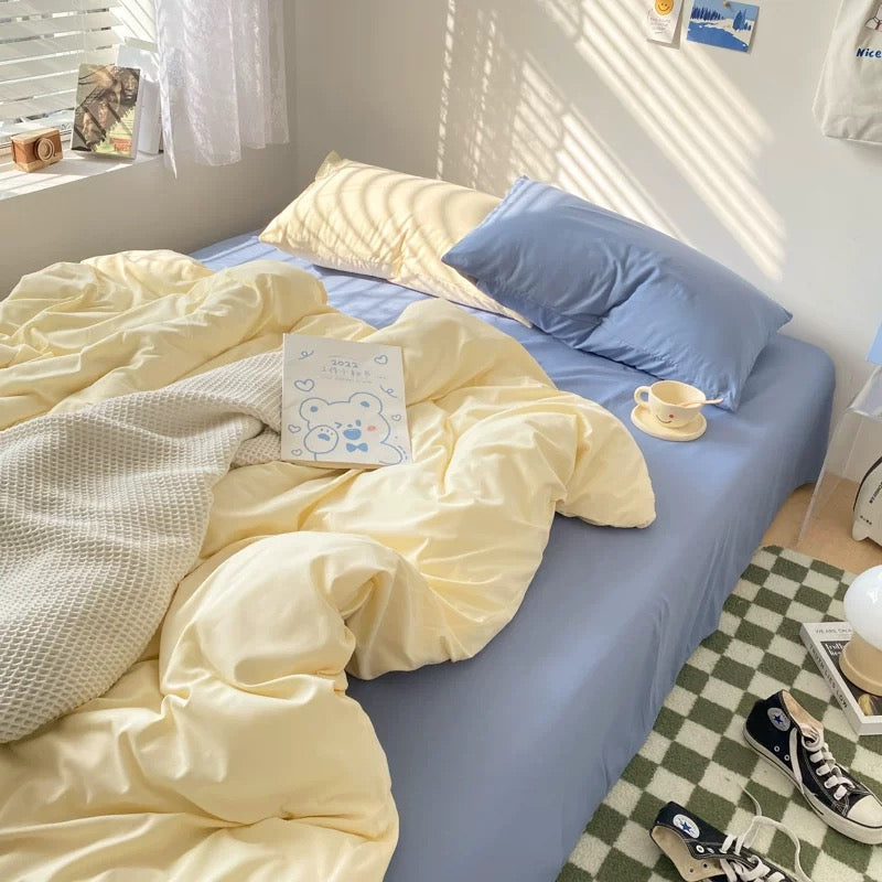 Minimalist pastel blue and cream bedding set styled in a cozy dorm room with sunlight.
